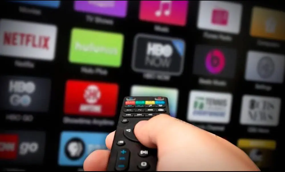Hand holding remote while browsing IPTV apps on Smart TV — Smarters Pro